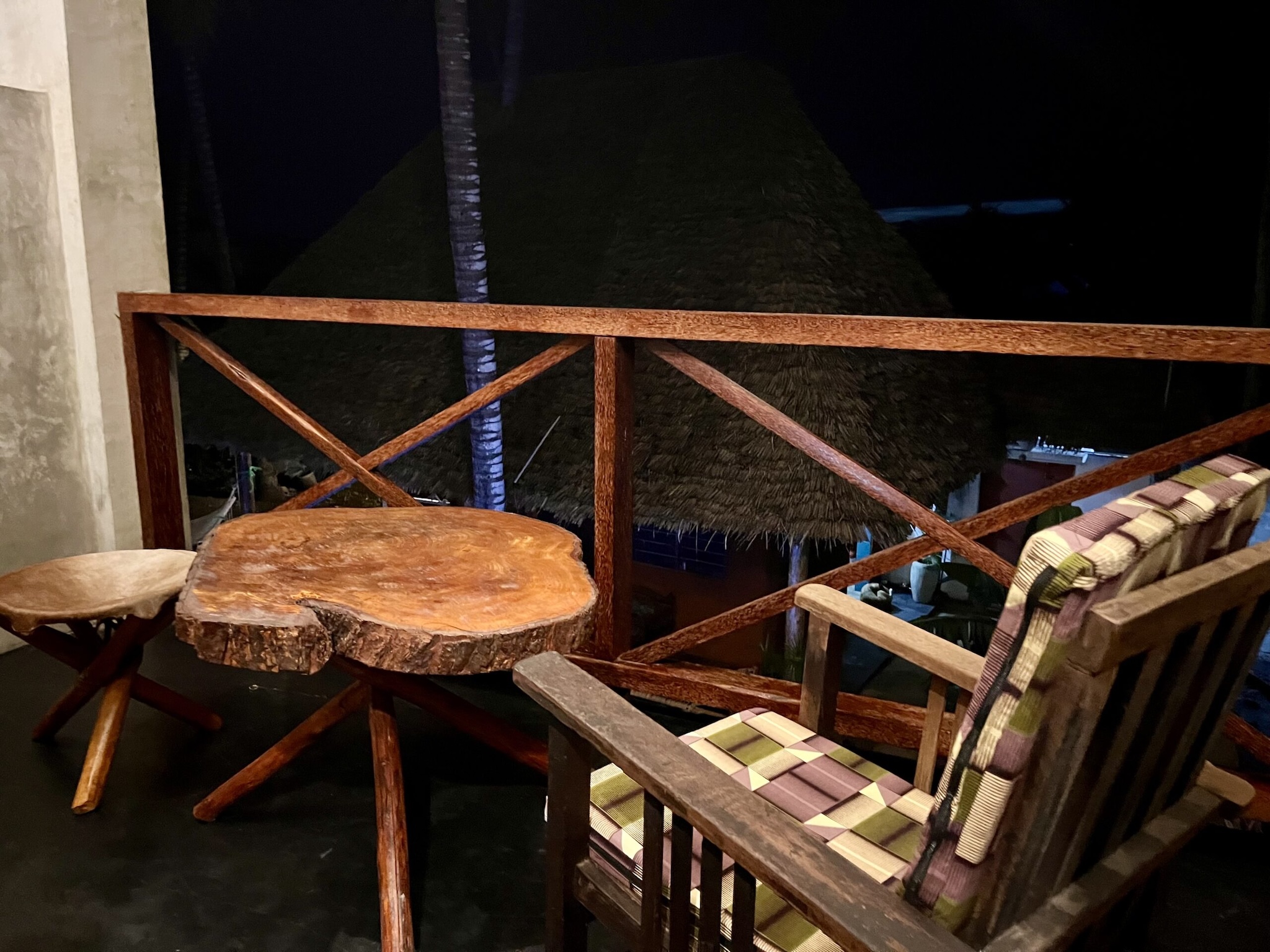 Wooden chair and table on balcony at night in Zanzibar.