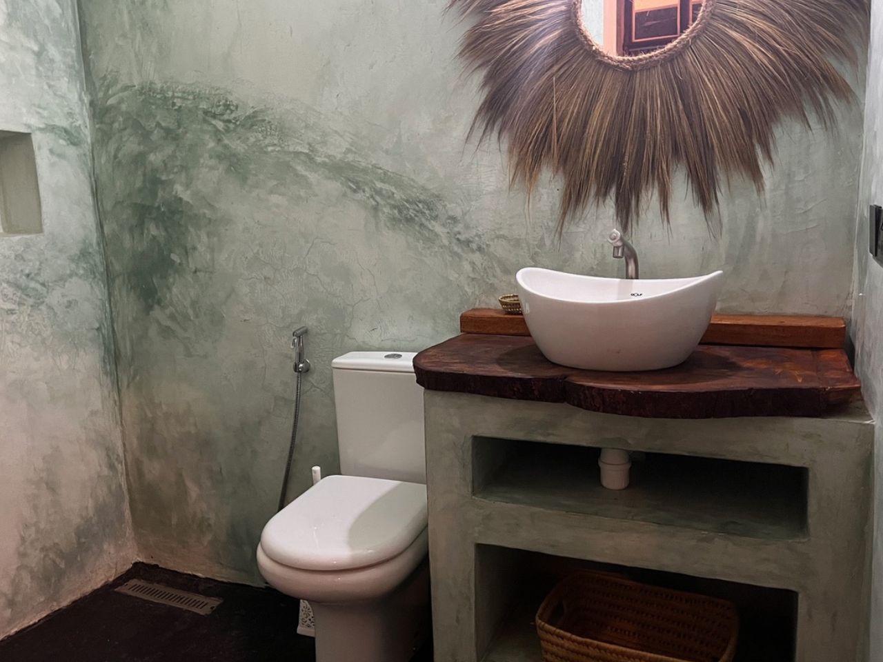 Bathroom with natural stone walls and wooden vanity at BamBam Bungalows Zanzibar