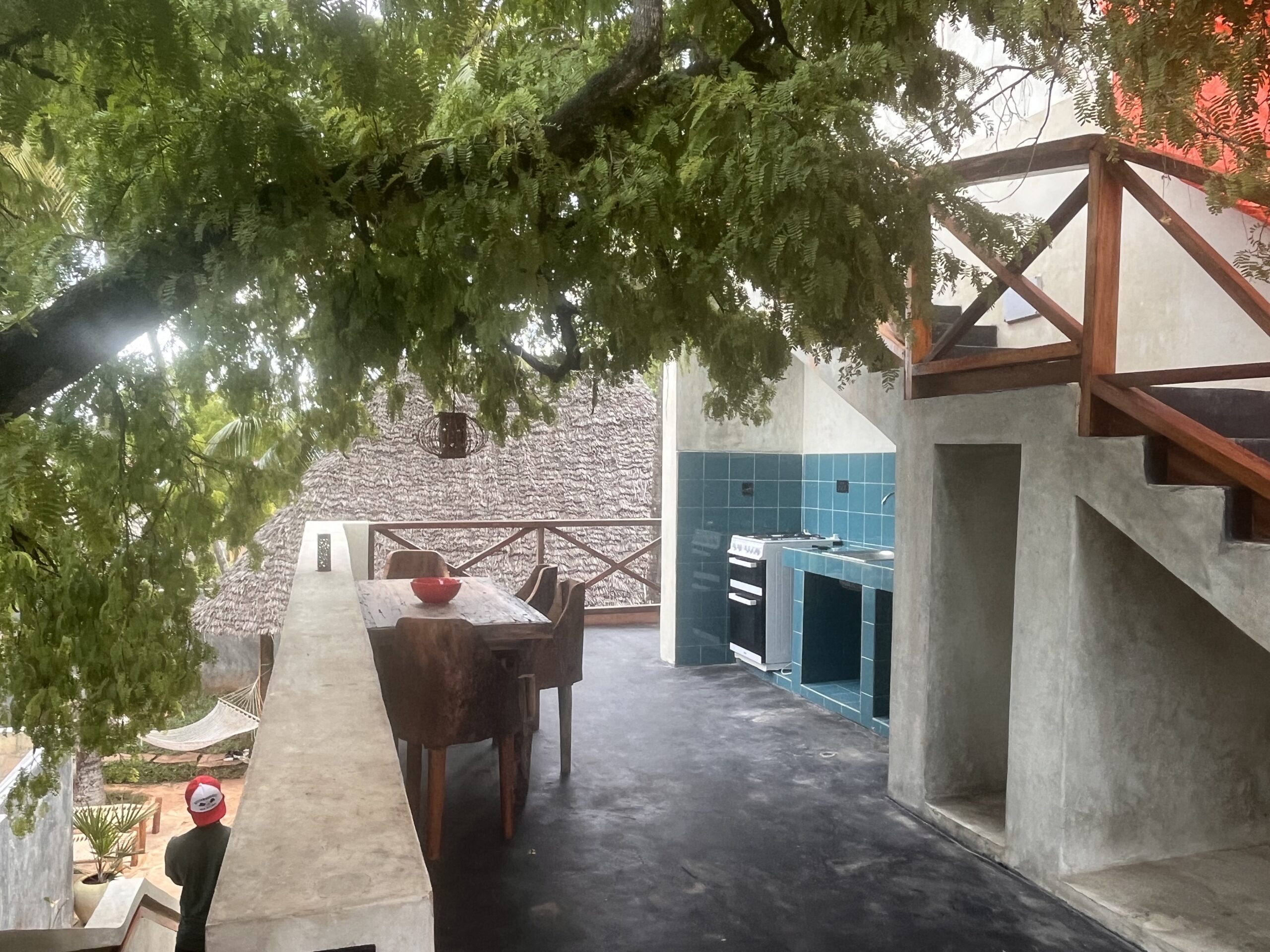 Open terrace with outdoor kitchen and dining area in a Zanzibar bungalow.